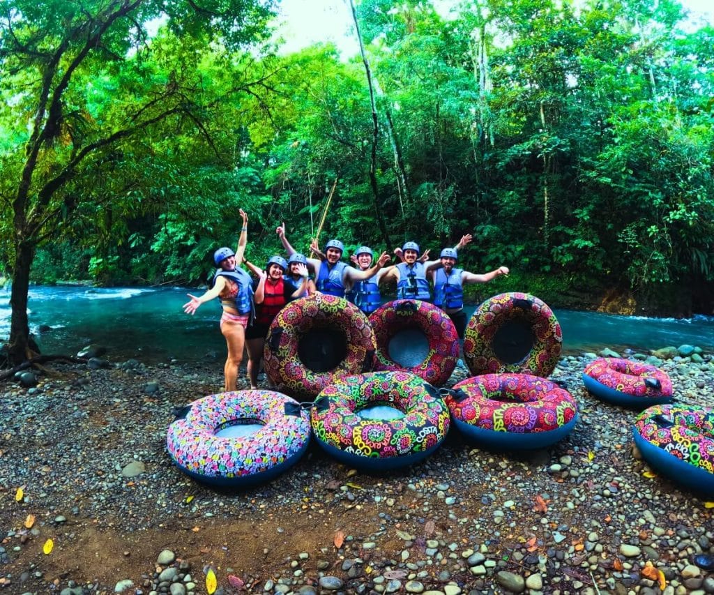 a group of people standing next to a group of rubber tubes
