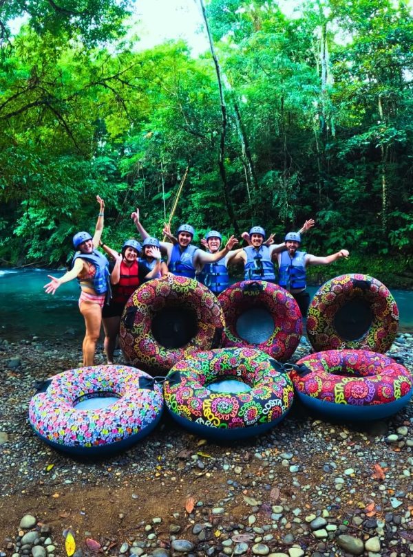 a group of people standing next to a group of rubber tubes