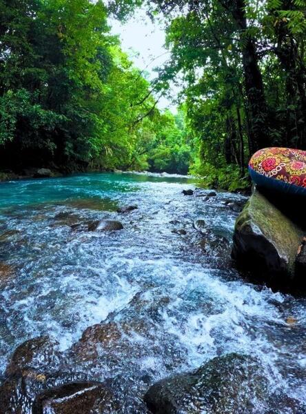 Inner tube resting on a rock in turquoise waters along the rio celeste river tubing route.