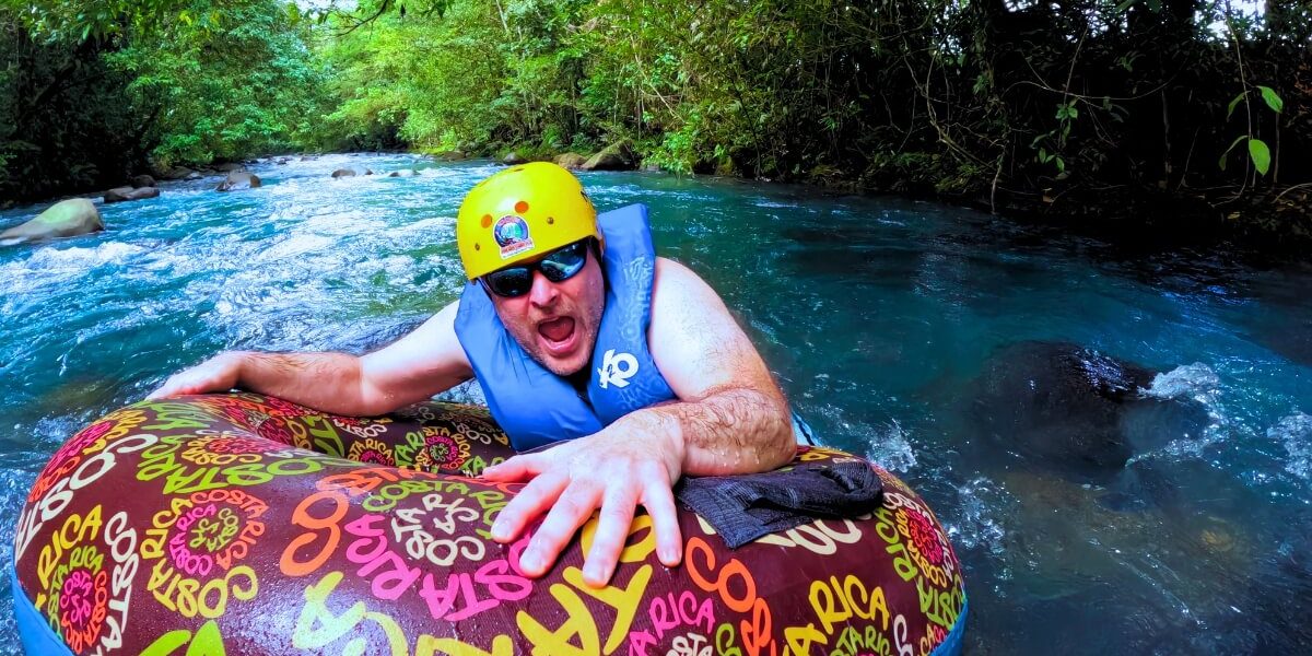 a man in a life jacket on a tube in a river