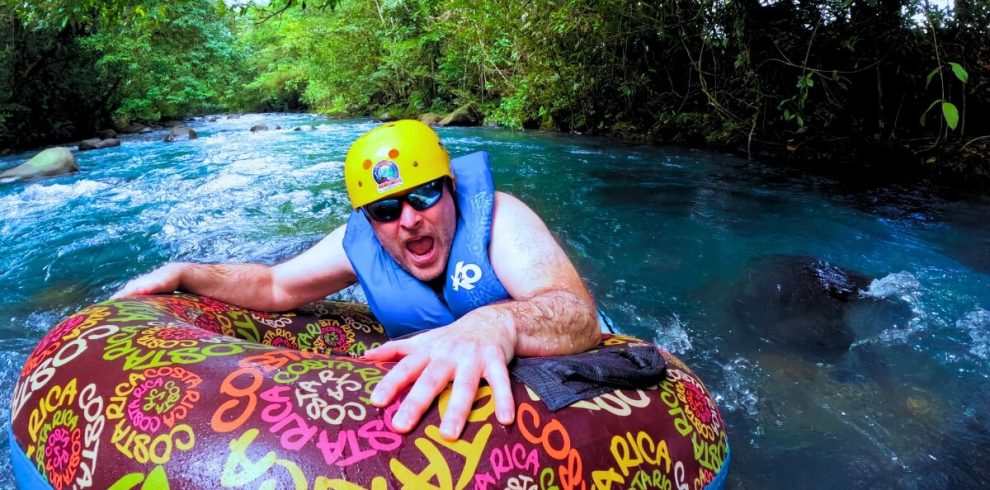 a man in a life jacket on a tube in a river