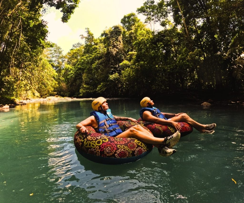 two people floating on inner tubes in a river